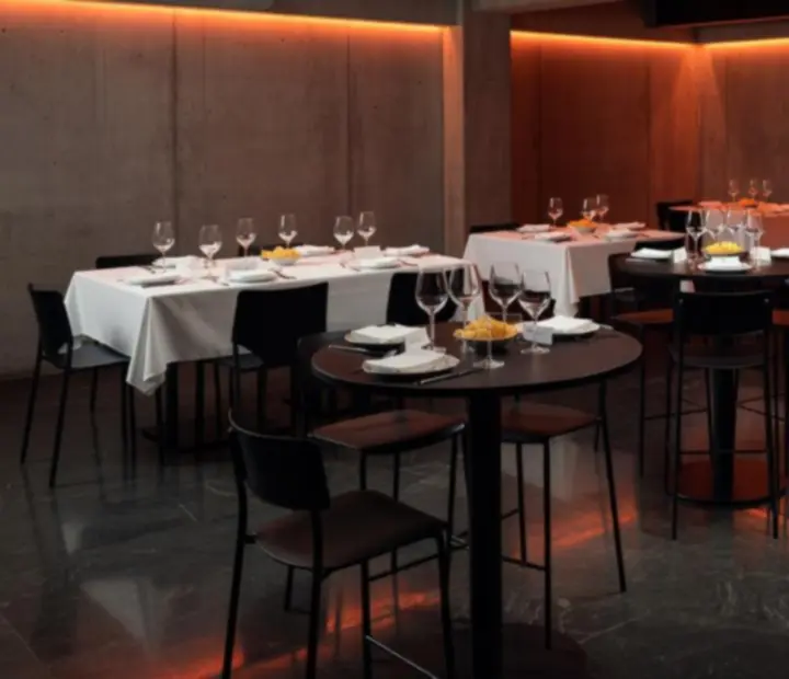 Vue d'ensemble d'un salon privatif modulable avec tables et lumière orange