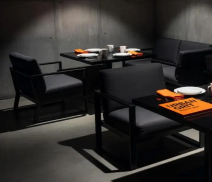 Design brutaliste noir et orange du restaurant-lounge Rendezvous Hub.